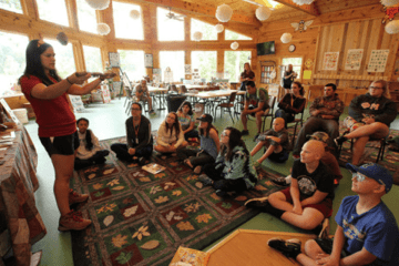 A woman talking to a group circle.