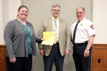 Three people standing side by side. 