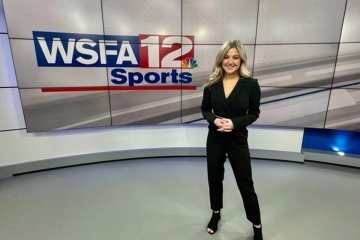 A girl standing in front of a WSFA12Sports sign.