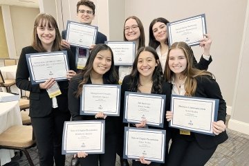 A group standing together, each holding an award. 