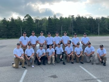 A group of police academy students posing for a picture together. 