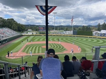 A baseball field with a crowd. 