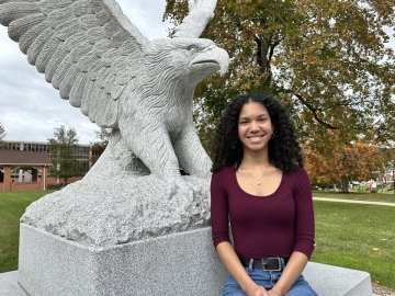 Picture of a woman in front of a bird statue. 