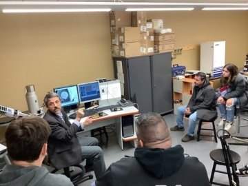 Group looking and talking around a computer. 