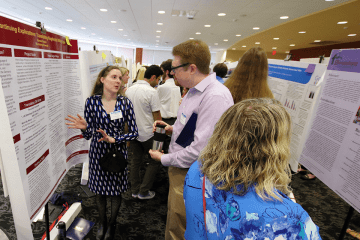 A group of people looking and talking about an information board. 