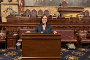 A woman standing behind a podium in a court room. 