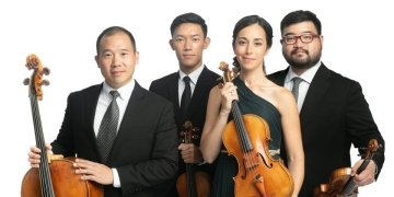 A group of musicians sitting together with their instruments.