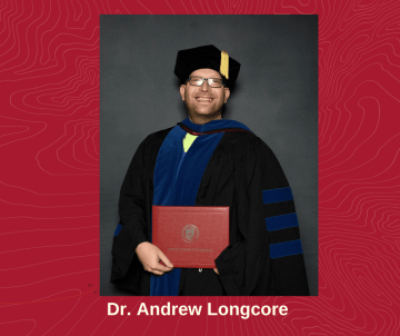 A photo of Dr. Andrew Longcore holding an award. 