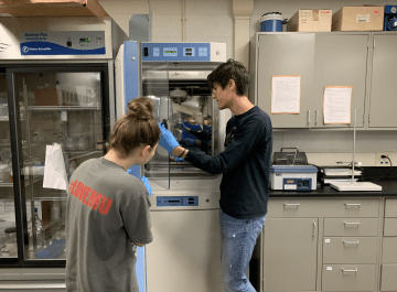 Two people standing with each other in a lab setting. 