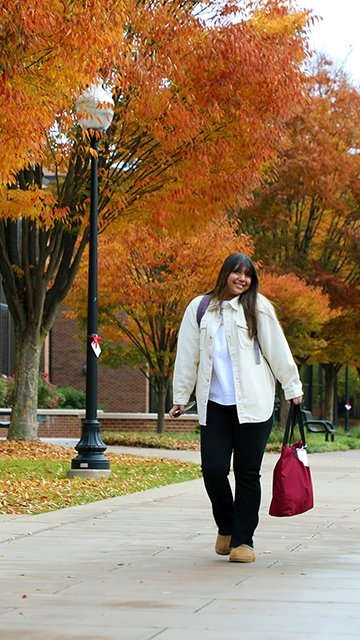 Nursing student walks to class during the fall at Commonwealth University-Bloomsburg, formerly Bloomsburg University