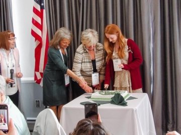 A group of three cutting cake. 