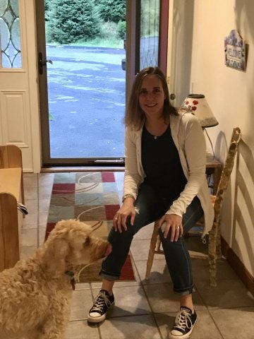 A woman sitting with a dog. 