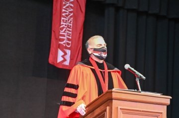 Bashar Hanna speaking, standing behind a podium. 