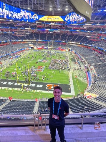 Hunter Confer standing in the seats of a stadium. 