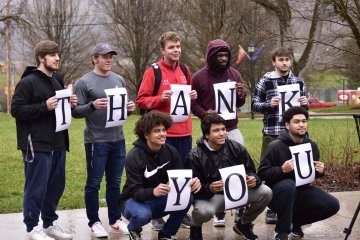 A group of people holding letters that spell out Thank You 