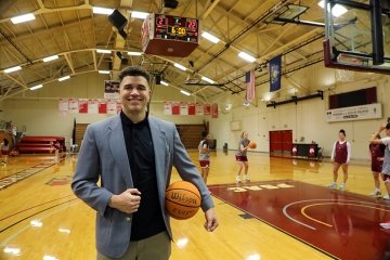 A Sport Management major standing in the CU-Lock Haven gym with a basketball