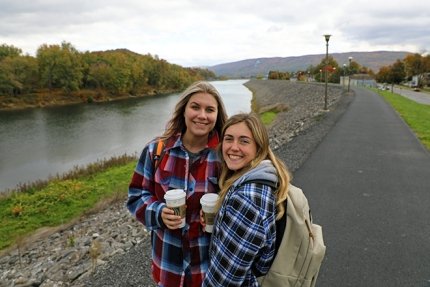 Friends stop for a quick photo while enjoying the levee walkway at Commonwealth University-Lock Haven, formerly Lock Haven University.