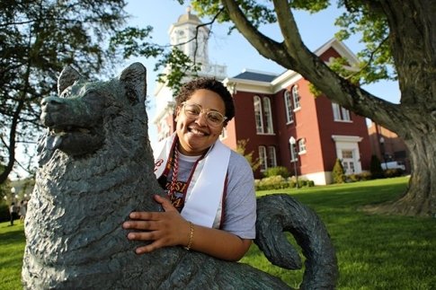 Student Kayla Barnett outside with the husky statue.