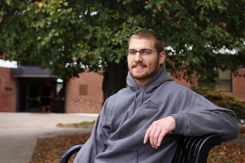 Eric Zalewski sitting on a bench on the campus of Commonwealth University - Bloomsburg