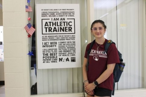 Athletic Training student standing in front of a Athletic Training sign