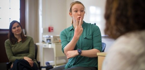 Commonwealth University student using American Sign Language in classroom setting.