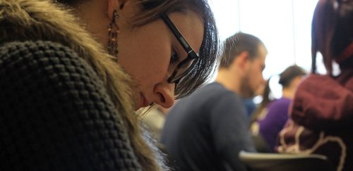 Student taking notes in an Economics class