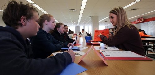 Female Commonwealth University student instructing middle school students at local school.