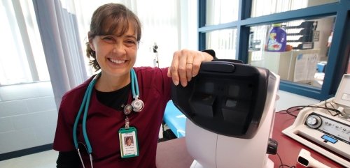 a nurse posing in a hospital smiling at the camera