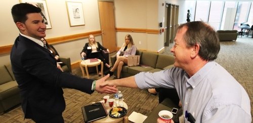 Student greeting a representative during a sales competition