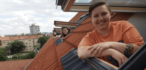 Students posing outside a window during a study abroad trip