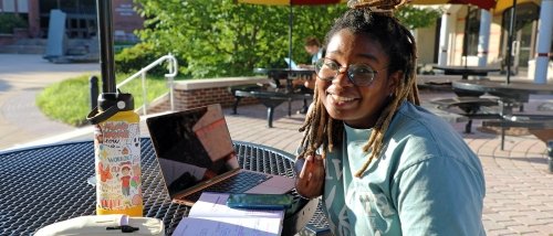 Student working on their laptop during a beautiful day on the Bloomsburg campus