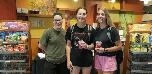 Two female students stand with food service employee at CU-Mansfield