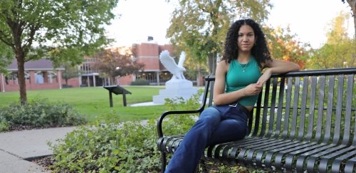 Melanie Jorge sitting on bench on the campus of CU-Lock Haven