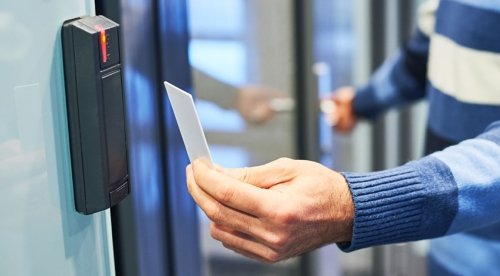 Man using ID card to gain access to door.