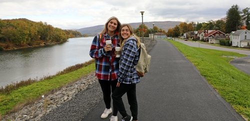 Friends take a coffee break as they walk along the levee at Commonwealth University-Lock Haven, formerly Lock Haven University.