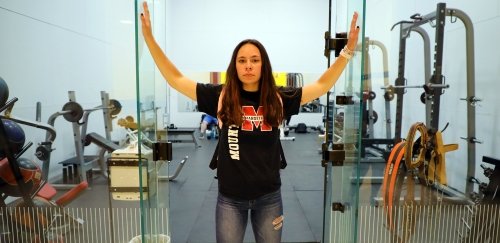 Student stands at the door of the campus at Commonwealth University-Mansfield, formerly Mansfield University.