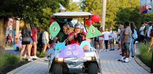 Students ride down Ivy Lane at Commonwealth University-Lock Haven, formerly Lock Haven University, as part of the annual golf cart parade.