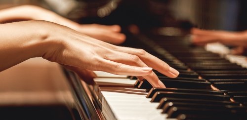 Close up view of female hands playing piano