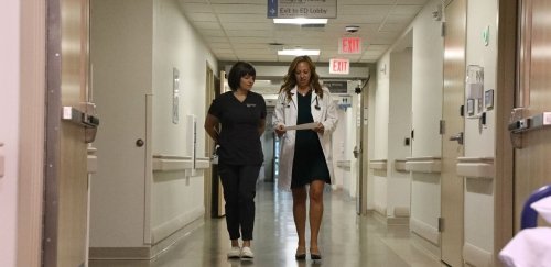 DNP graduate walking down a hallway in a hospital with a colleague