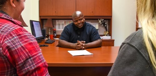 Kenny Hall talking with students in his office at CU-Lock Haven