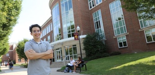 Economics student standing in front of Sutliff Hall