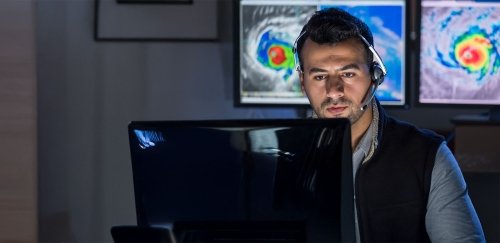 Meteorologist working on computer looking at radar of hurricane.