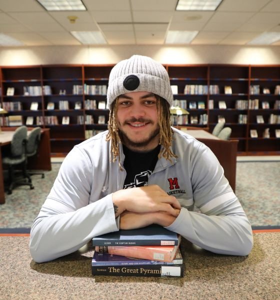 Student sitting with books