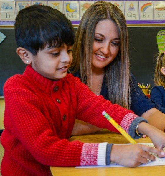 Student teacher observing student writing