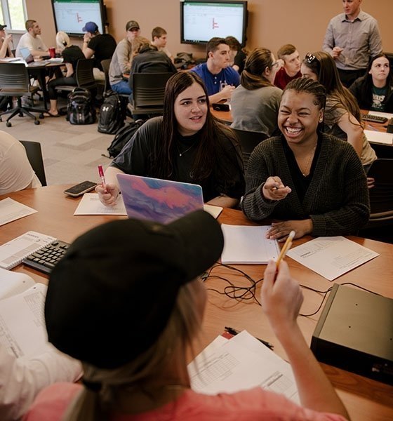 Students laughing and talking in a supply chain class.