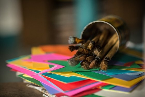 Paint brushes on top of colored paper