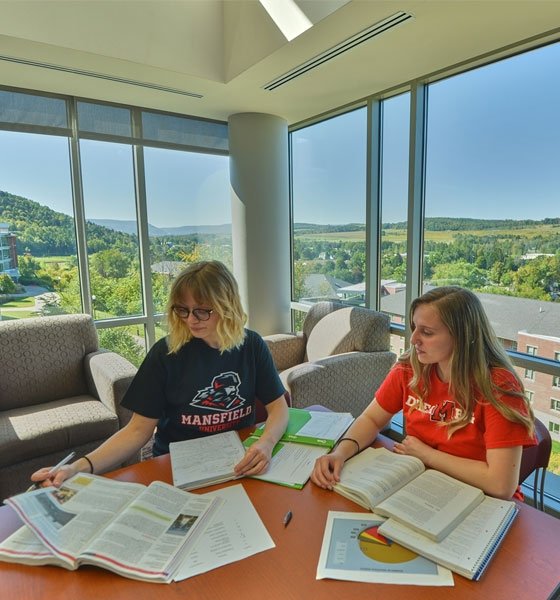 Two female students study in lounge of residence hall at CU-Mansfield