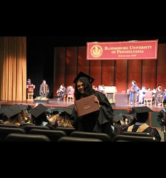 Health Science graduate holding diploma