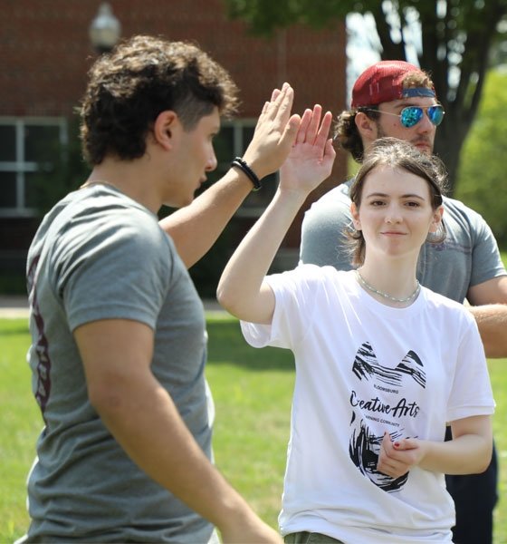 Male and female Learning Community mentees high-five.