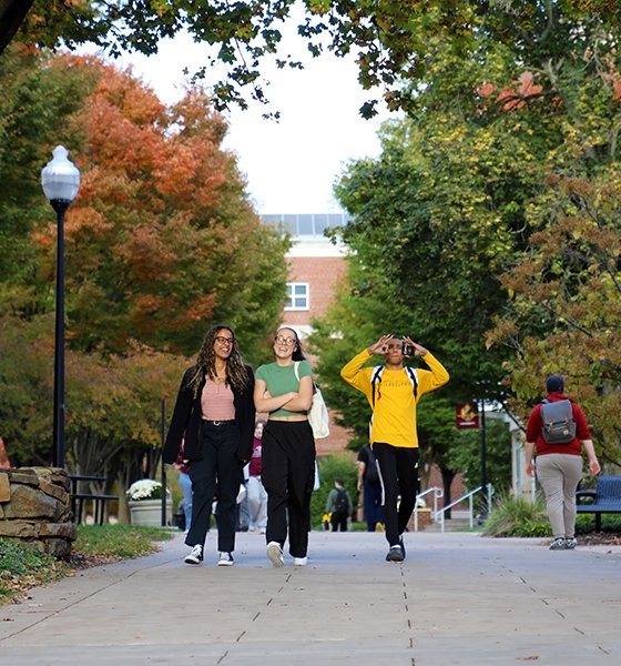 Friends walk from class in the fall at Commonwealth University-Bloomsburg, formerly Bloomsburg University.